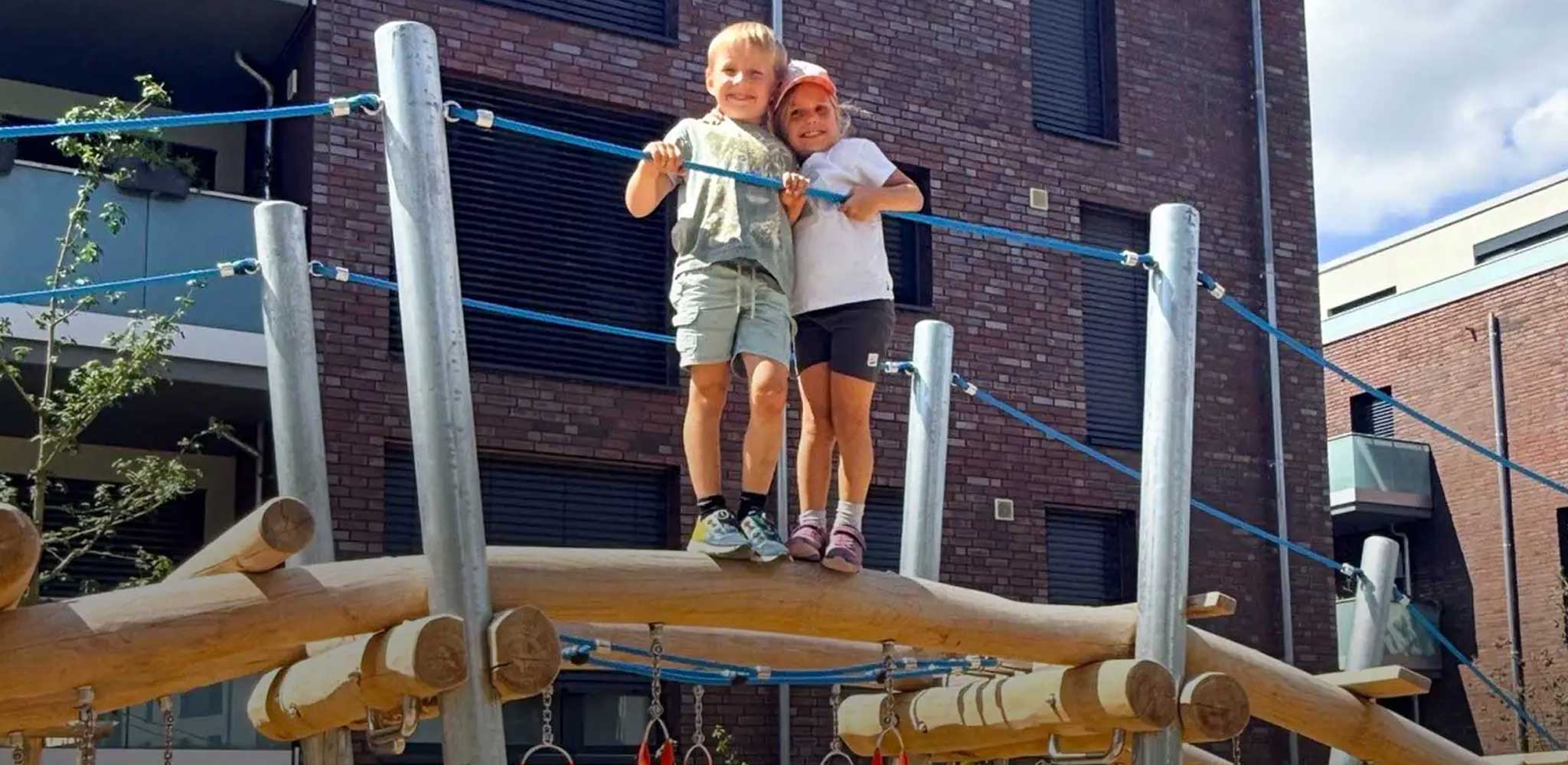Kinder auf dem neu eröffnetem Kletterspielplatz
